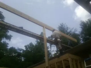 Carpenter setting a ridge beam over a new addition frame — Ice Dam Removal by Roofing Brothers in Cragsmoor