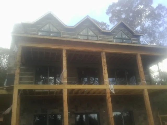 Dormers and porch framing on a large log home under construction — Roof Coating work by our crew in Cragsmoor
