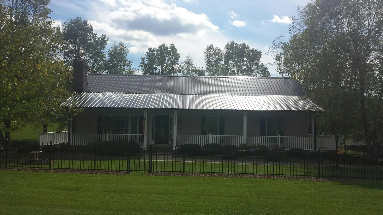 Gray metal roof on a brick ranch with a full width front porch — Gutter Guard Installation work by our crew in Cragsmoor