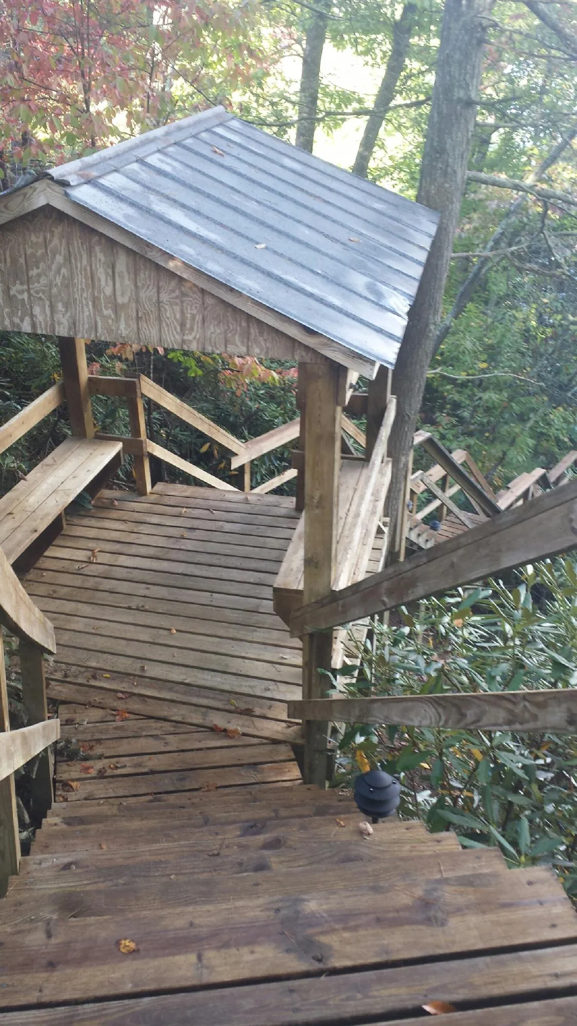 Metal roofed shelter over wooden steps on a wooded walkway — Skylight Repair & Installation work by our crew in Cragsmoor